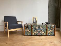 an old suitcase sitting next to a blue chair