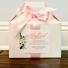 a welcome card in a white box with pink ribbon