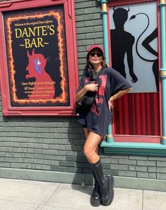 a woman is standing in front of a sign for the dance's bar at universal studios