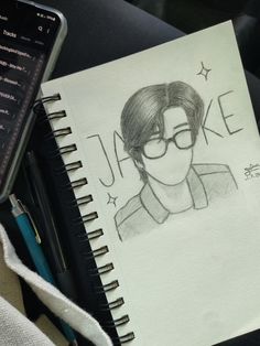 a drawing of a man with glasses on top of a notepad next to a cell phone