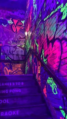 the stairs are covered in graffiti and lit up