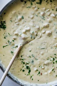 a pot filled with soup and a wooden spoon