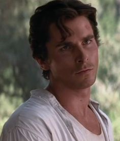 a close up of a person wearing a white shirt and looking off into the distance