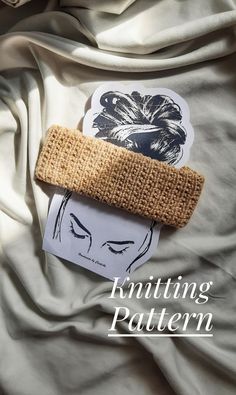 a piece of cloth on top of a bed with the words knitting pattern next to it