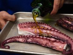 an octopus being drizzled with mustard from a bottle