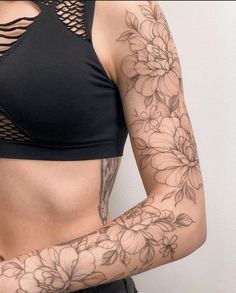 a woman with flowers on her arm and chest is wearing a black bra - top