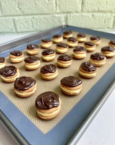 chocolate frosted donuts sitting on top of a cookie sheet