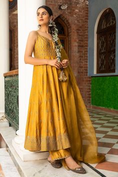 Mustard anarkali with floral motif zari embroidery. Comes with silk pant and dupatta.
Component: 3
Pattern: Embroidered
Type Of Work: Floral Motifs
Neckline: V-Neck
Sleeve Type: Sleeveless
Fabric: Anarkali and Pant: Silk, Dupatta: Organza
Color: Yellow
Other Details: 
Floral motif embroidery
Sheer dupatta
Occasion: Mehendi and Haldi - Aza Fashions Tussar Silk Palazzo Set For Festivals, Anarkali Tussar Silk Set With Traditional Drape, Anarkali Tussar Silk Set, Festive Tussar Silk Palazzo Set For Eid, Eid Festive Tussar Silk Palazzo Set, Festive Eid Tussar Silk Palazzo Set, Unstitched Raw Silk Anarkali Set With Zari Work, Resham Embroidered Raw Silk Anarkali Set With Traditional Drape, Resham Embroidered Anarkali Set With Traditional Drape