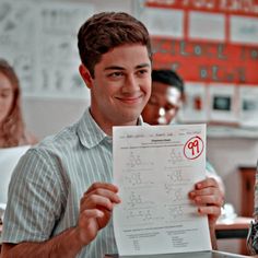 a man holding up a piece of paper with numbers on it in front of him