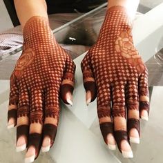 a woman's hands with hennap on her hand and nails in the middle