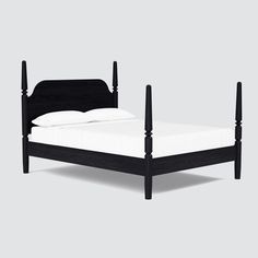 a black bed frame with white sheets and pillows on top of it, against a gray background