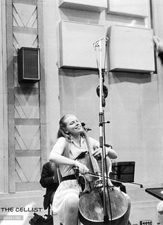 a woman sitting in a chair playing an instrument