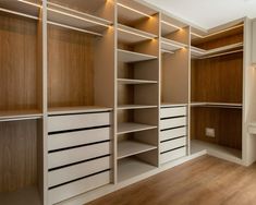 an empty walk in closet with wooden shelves