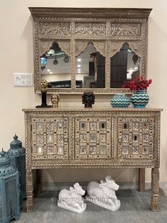 an ornately decorated dresser with mirrors and vases on it's sideboard