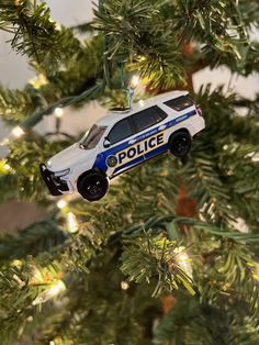 a police car ornament hanging from a christmas tree