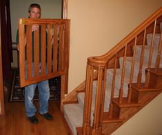 a man standing in front of a wooden stair case next to a set of stairs