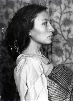 an old black and white photo of a woman with a basket on her shoulder, looking to the side