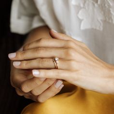 a woman's hand with a diamond ring on her left wrist, sitting down