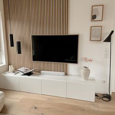 a flat screen tv sitting on top of a white entertainment center in a living room