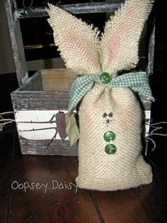 a burlap bag with a green bow on it sitting next to a wooden box