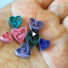 a person is holding several small hearts in their hand, with the video below it