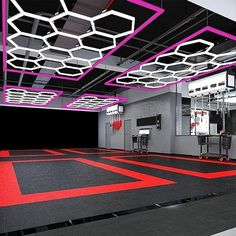 an empty gym with red and black flooring, mirrors and lights on the ceiling