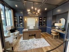 a living room filled with furniture and a chandelier hanging from the ceiling over a wooden floor