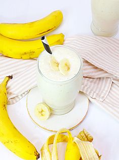 a banana smoothie in a glass with bananas around it