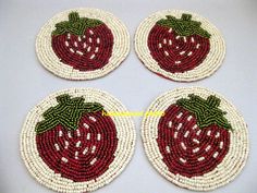 four red and white coasters with strawberries on them