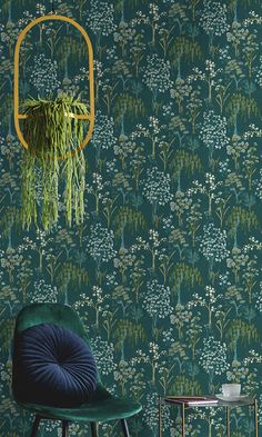 a chair and table in front of a wallpapered room with green plants on it