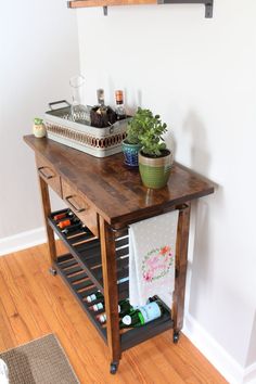 a wooden table with bottles on it and a potted plant sitting on top of it