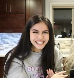 two young women are smiling and posing for the camera in front of a kitchen counter