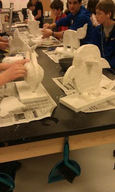 people working on paper sculptures at a table