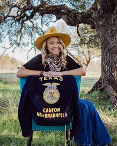 a woman wearing a cowboy hat sitting in a chair holding a t - shirt that says canyon new braunies