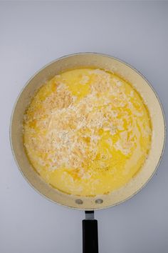 an omelet with cheese in a pan on top of a stove burner