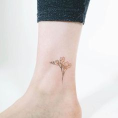 a small flower tattoo on the ankle that is very feminine and delicate, it looks as if it has been done by someone else