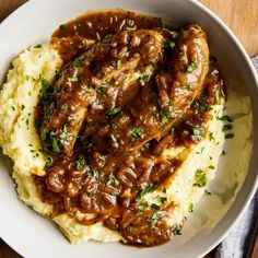 a white plate topped with mashed potatoes covered in gravy