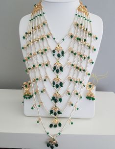 an elaborate necklace with green and white beads