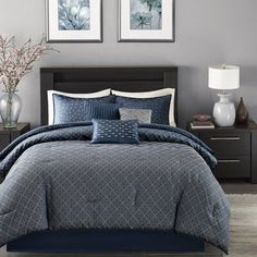 a bed in a bedroom with blue comforters and pillows