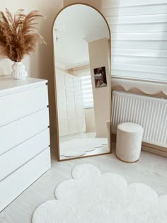 a large mirror sitting on top of a white dresser