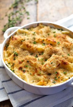 a casserole dish with cheese and parmesan toppings on a towel