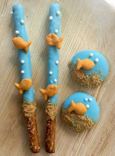 three decorated cookies sitting on top of a wooden table