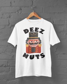 This customized Deez Nuts Nutcracker funny shirt designs, Unisex Tee Shirt, Graphic tee shirt, Shirts for men, shirts for women can be used by all the members of family, it will be the best wanderlust, travel apparel unisex personalized shirt ever!  We have men and women style shirts most sizes in stock Nutcracker Funny, Funny Shirt Designs, Christmas Sales, Deez Nuts, Men Shirts, Graphic Tee Shirt, Shirts For Women, Holiday Shirts, Funny Shirt