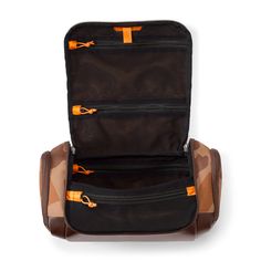 an open suitcase sitting on top of a white floor next to a bag with orange zippers