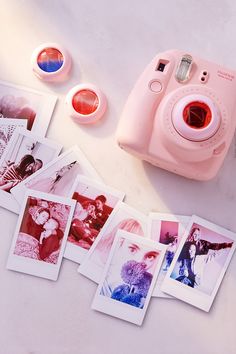 polaroid camera sitting on top of a table next to pictures