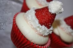 some cupcakes with white frosting and strawberries on top