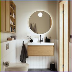 a bathroom with a round mirror above the sink