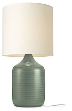 a green lamp with a white shade on it