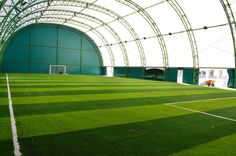 an indoor soccer field with green grass