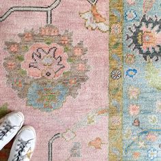 someone is standing on the floor next to a rug with different colors and patterns in it